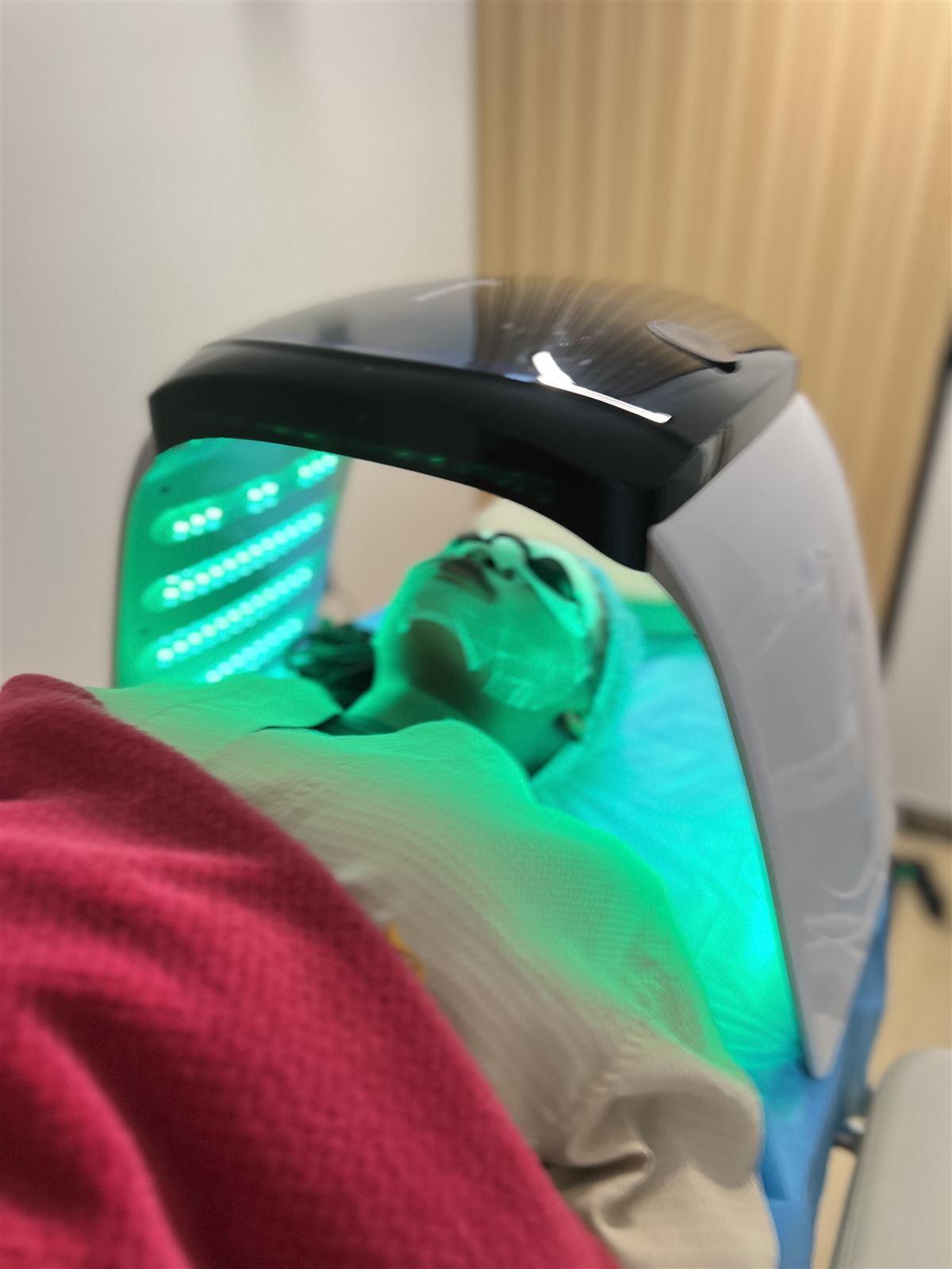 Green LED light therapy dome over a client's face